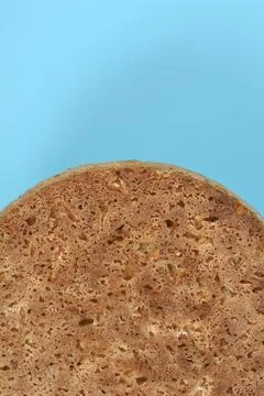 Vertical brown bread loaf on blue background Stock Photos