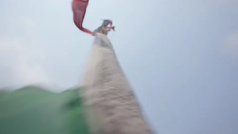 Vertical buddhist prayer flags flapping on pole, sacral letterings sway in wind Stock Footage 167325356