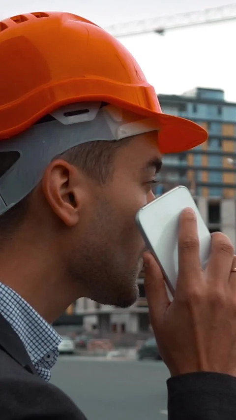 Vertical of Builder in a orange helmet is making call Stock Footage 305505366