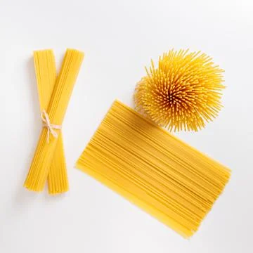 A vertical bunch and a bunch of raw spaghetti tied with string. Bundle on a w Stock Photos