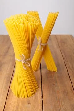 A vertical bunch and a bunch of raw spaghetti tied with string. Bundle on a Stock Photos