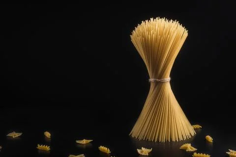 Vertical Bundle of Raw Spaghetti Pasta on Black Background Foto stock