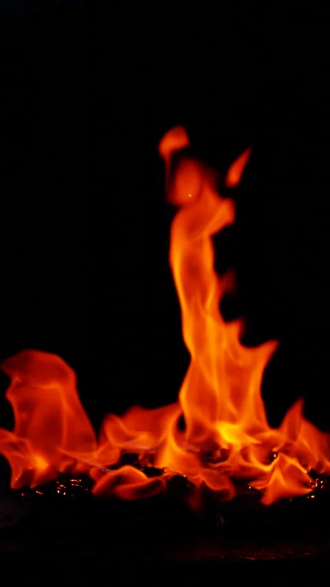 Vertical burning fire flame on ground isolated on black background, slow motion Stock Footage 307581563