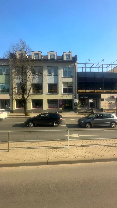 Vertical. Bus passenger window view of city centre in Lithuania. Stockbeeldmateriaal 295985642