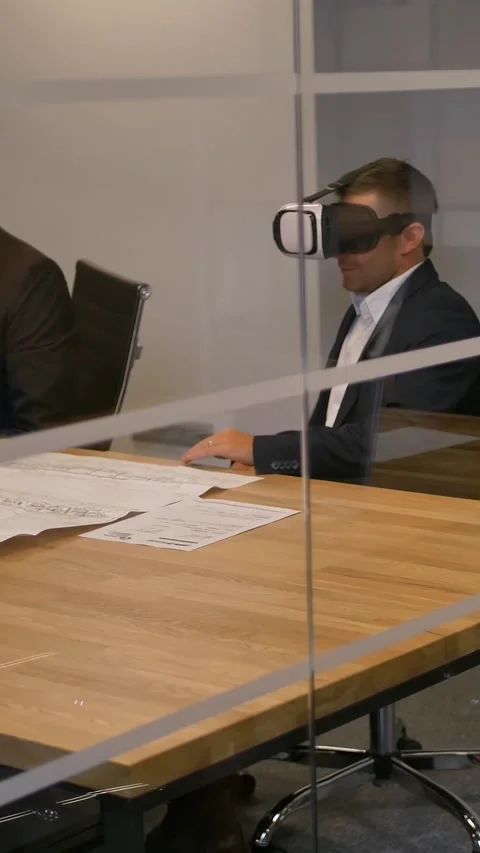 Vertical of Business team sitting at a table, man with virtual reality goggles Stock Footage 277277271