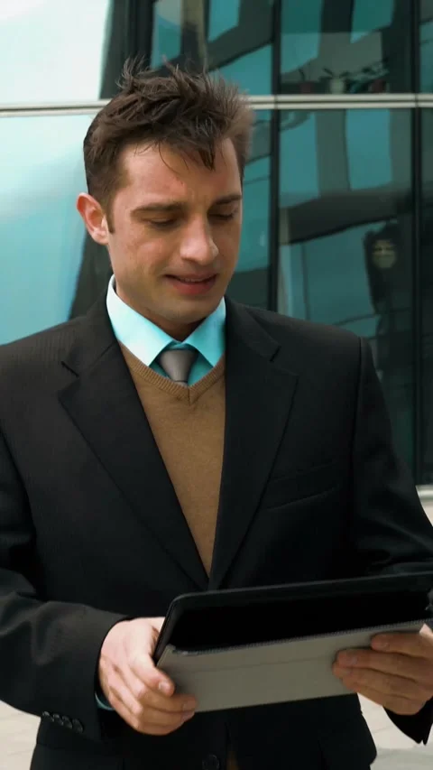 Vertical of Businessman using electronic tablet outside a building Stock Footage 305515298