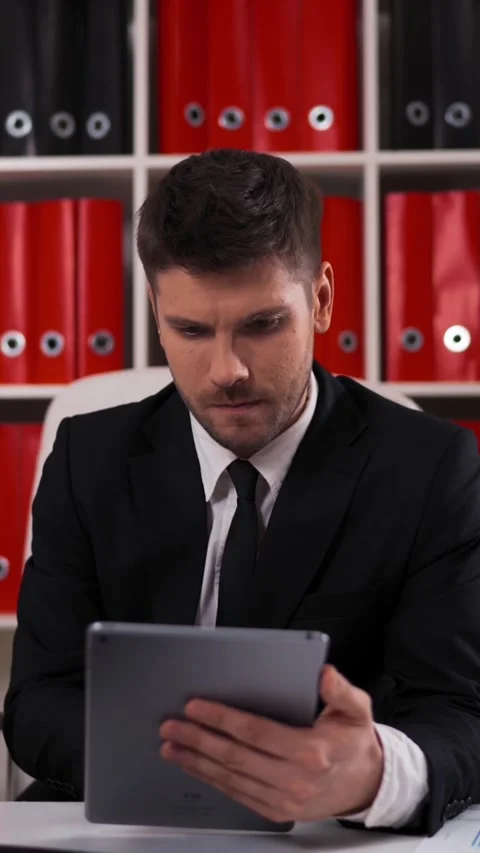 Vertical of businessman writing notes from ipad in business office Stock Footage 305454812