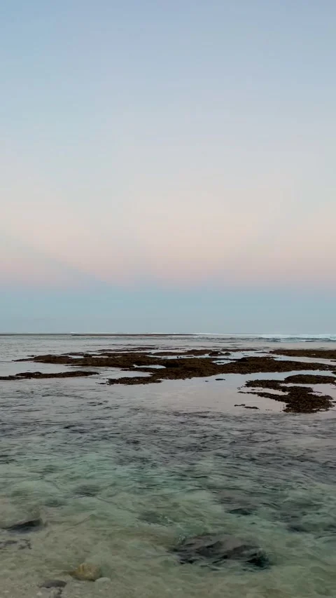 Vertical Calm Ocean Rocky Reef and Light Rays Sky in Bali Stock Footage 337354691