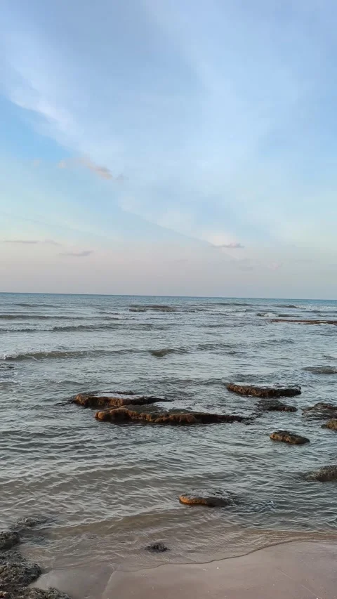 Vertical Calm Ocean Waves on Rocky Beach at Sunset Stock-Footage 340489775