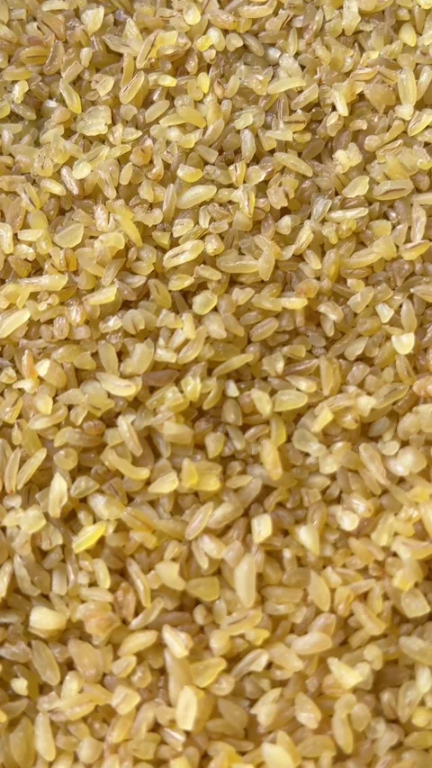 Vertical camera flyover above raw bulgur wheat groats macro texture Stock Footage 336506918