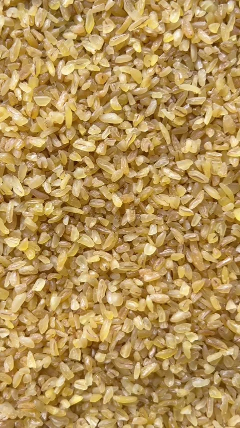 Vertical camera flyover above raw bulgur wheat groats macro texture Stock Footage 336506928