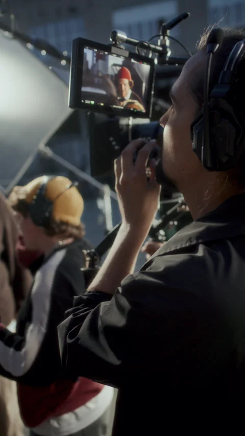 Vertical of Camera Operator Watching Field Monitor Screen on Movie Set Stock Footage 336703998