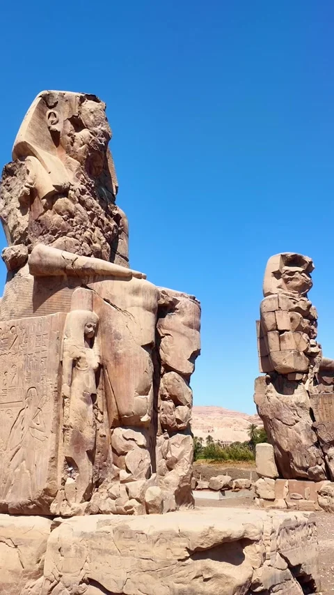 Vertical camera panning right over Colossi of Memnon, in Luxor, Egypt Stock Footage 332781873