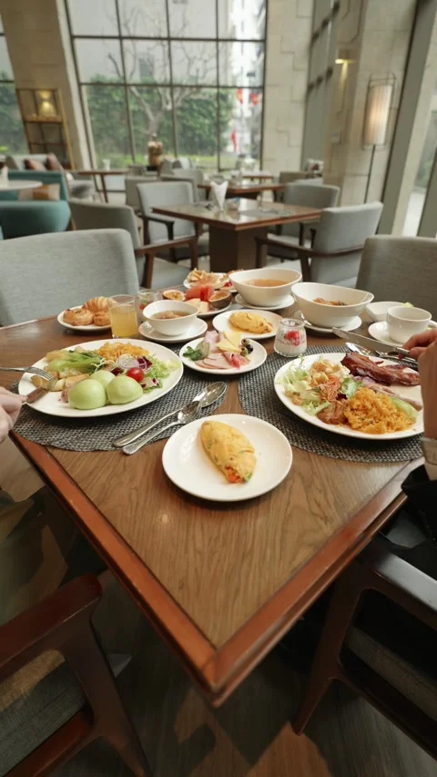 Vertical camera pans up and down over a couple dining at a hotel restaurant 動画素材 335449644