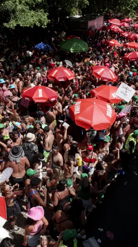 Vertical camera pans left over a dense Rio de Janeiro Carnaval crowd dancing Stock Footage 336589880