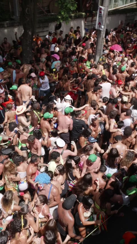 Vertical camera pans right and left over people dancing in a dense Rio de Stock Footage 336589875