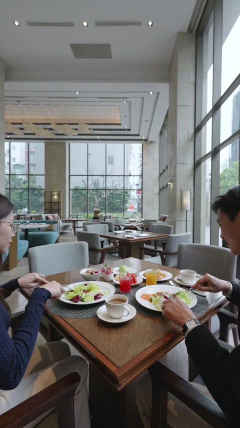 Vertical camera pushes in and out on a couple dining in a luxury hotel 動画素材 335433051