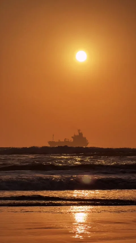 Vertical Cargo Ship Silhouette at Dawn on Empty Beach with Waves and golden Stock Footage 342582985