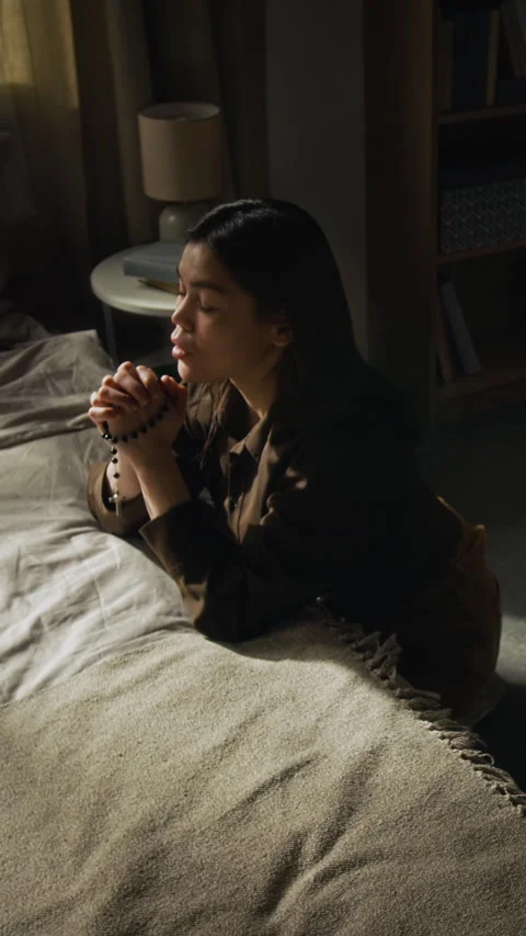 Vertical of Catholic Girl Asking for Divine Help while Kneeling in Bedroom Stock Footage 327459813