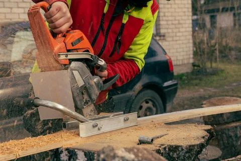 Vertical chainsaw mill cutting tree logs on boards Stock Photos