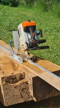 Vertical chainsaw mill cutting tree logs on boards Stock Photos