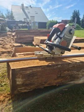 Vertical chainsaw mill cutting tree logs on boards Stock Photos