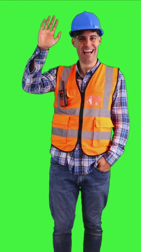 Vertical Cheerful construction worker waving to the camera, wearing orange .. Stock Footage 287328011