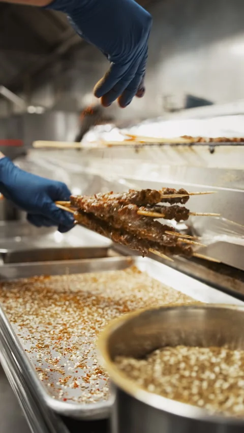Vertical chef hands removing grilled meat skewers from restaurant barbecue Stock-Footage 333877918