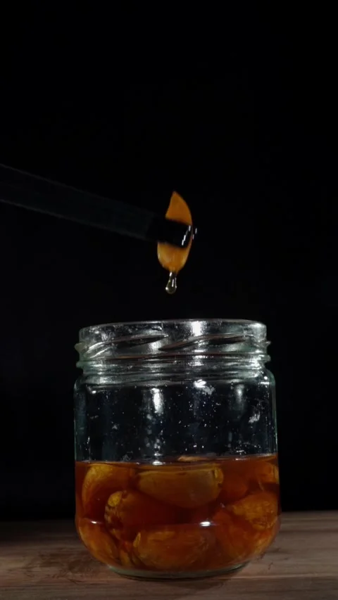 Vertical Chef Tweezers Lifting Fermented Garlic Honey Drip Slow Motion Stock Footage 324920333