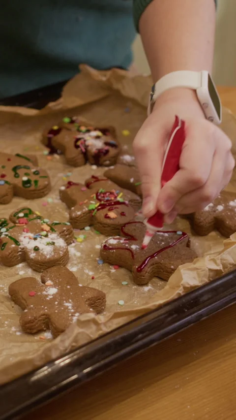 Vertical of Child Decorating Christmas Gingerbread Cookies with Icing Stock Footage 346884327