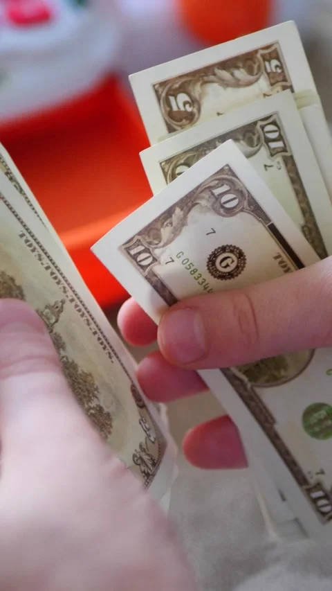 Vertical. A child's hands carefully handle play money Vidéo 304628990