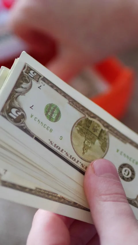 Vertical. A child's hands carefully handle play money Vidéo 304629007