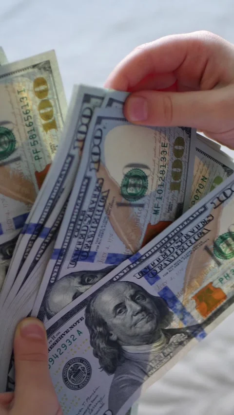 Vertical. A child's hands carefully handle play money Vidéo 304629394