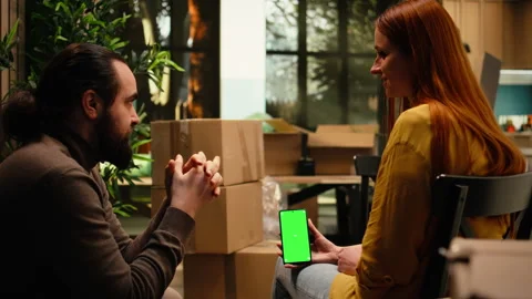Vertical chroma key on mobile phone with people unpacking belongings Stock Footage 342903487