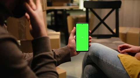 Vertical chroma key on mobile phone with people unpacking belongings Stock Footage 342906134