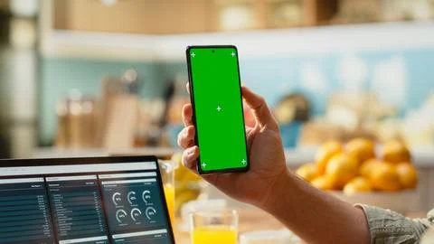 Vertical chroma key screen on smartphone used at home in kitchen Stock Photos