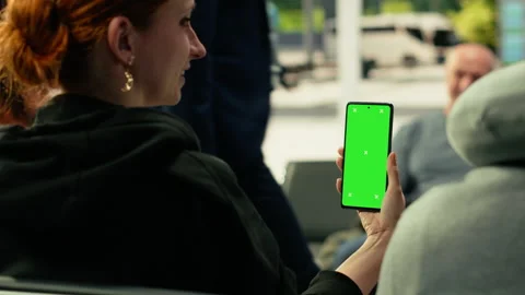 Vertical chroma key on smartphone held by black man waiting at bus stop Stock Footage 334730464