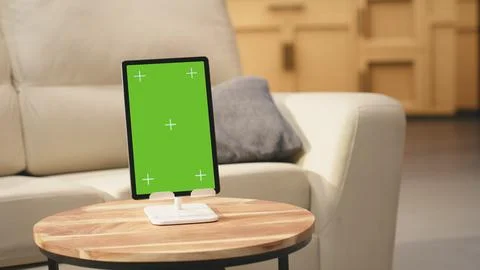 Vertical chroma key tablet in empty wooden table cozy open space Stock Photos