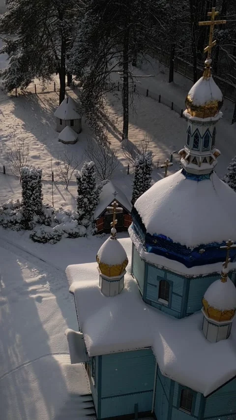 Vertical. Church with thick layer of snow resting on roof. Stands of dense park Video stock 327404785
