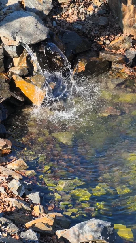 Vertical cinematic 4K B-roll footage slow motion waterfall rocky stream sunlit. Stock Footage 305780095