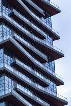Vertical clear of blue colored high-rise mass house building with glass facad Stock Photos
