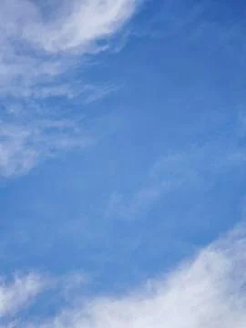 Vertical clear blue sky with soft white cirrus clouds background Stock Photos