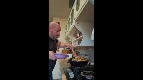 Vertical Clip of Man Scooping Tajine Onto His Plate in Her Kitchen Stock Footage 341669532