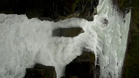 Vertical clip of a rushing white waterfall in slow motion.   Stock Footage 141468324