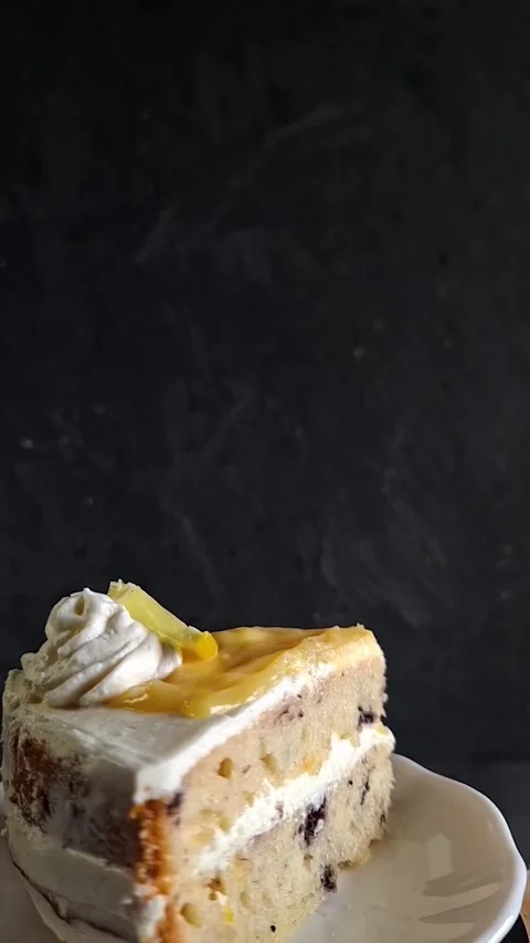 Vertical Clip of Slice of Lemon Blueberry Cake Spinning on a White Plate Stock-Footage 336147982