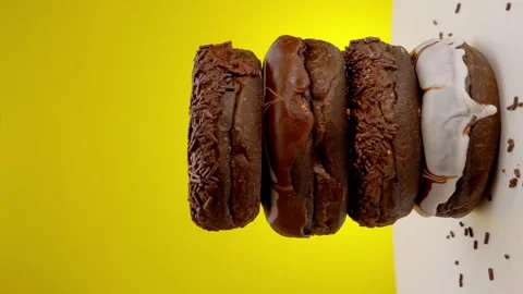 Vertical clip, Stack of chocolate donuts on a rotating wooden plate. Stock Footage 147069627