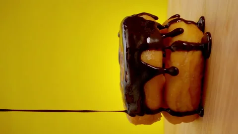 Vertical clip, Stack of donuts with chocolate cream on a rotating wooden plate. Stock Footage 146958889