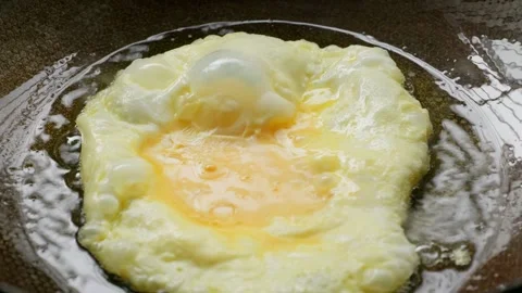 Vertical clip of whisked beaten eggs frying inside an iron wok pan. Stock-Footage 337451285