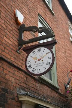 Vertical clock face shop sign on a red brick building in Lincoln 写真素材