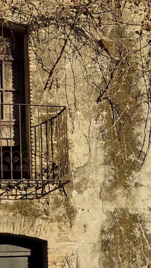 Vertical close up of abandoned Spanish house balcony shadow on wall slow mot Stock Footage 341737857